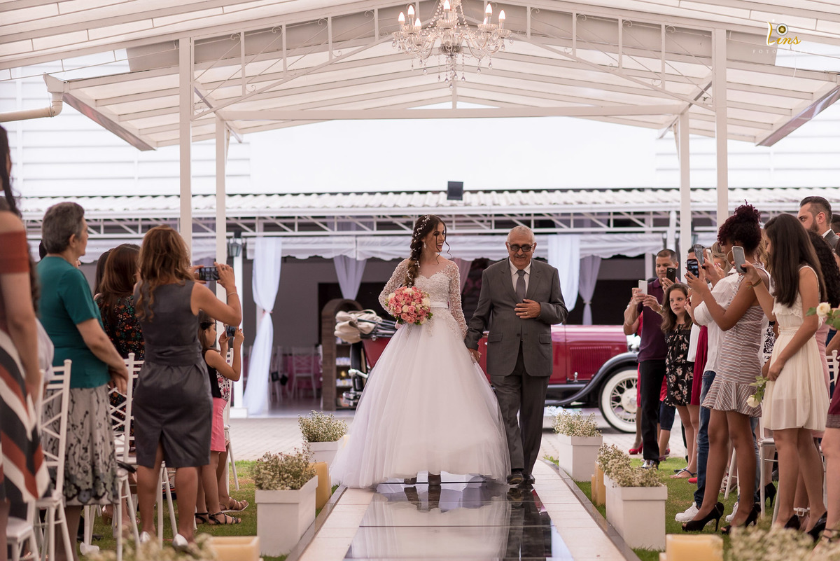 noiva sorrindo e olhando para seu Pai durante sua entrada no altar 