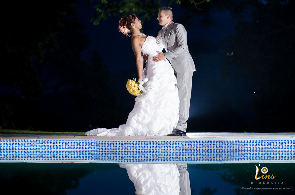 noivos posando em frente a piscina