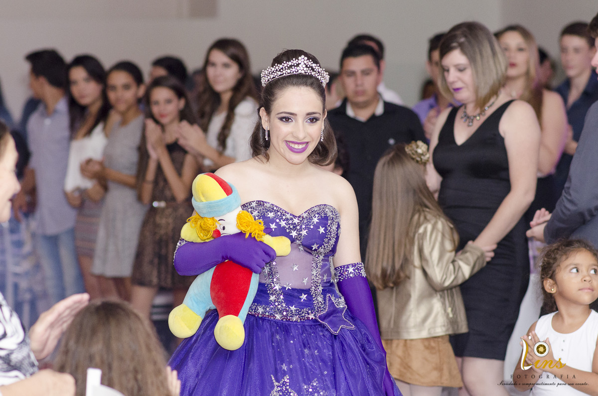 debutante com boneca entrando na festa