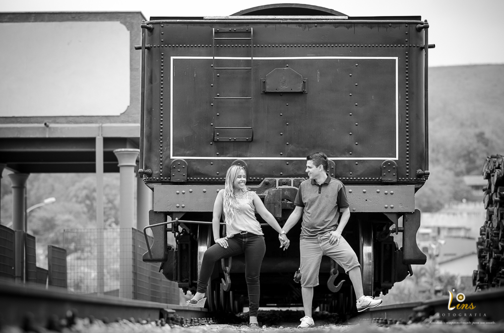 noivos de mãos dadas encostados em trem de guararema