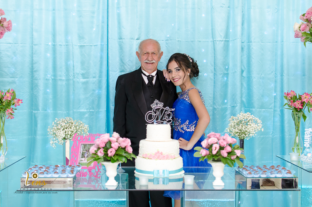 debutante com parentes na mesa do bolo