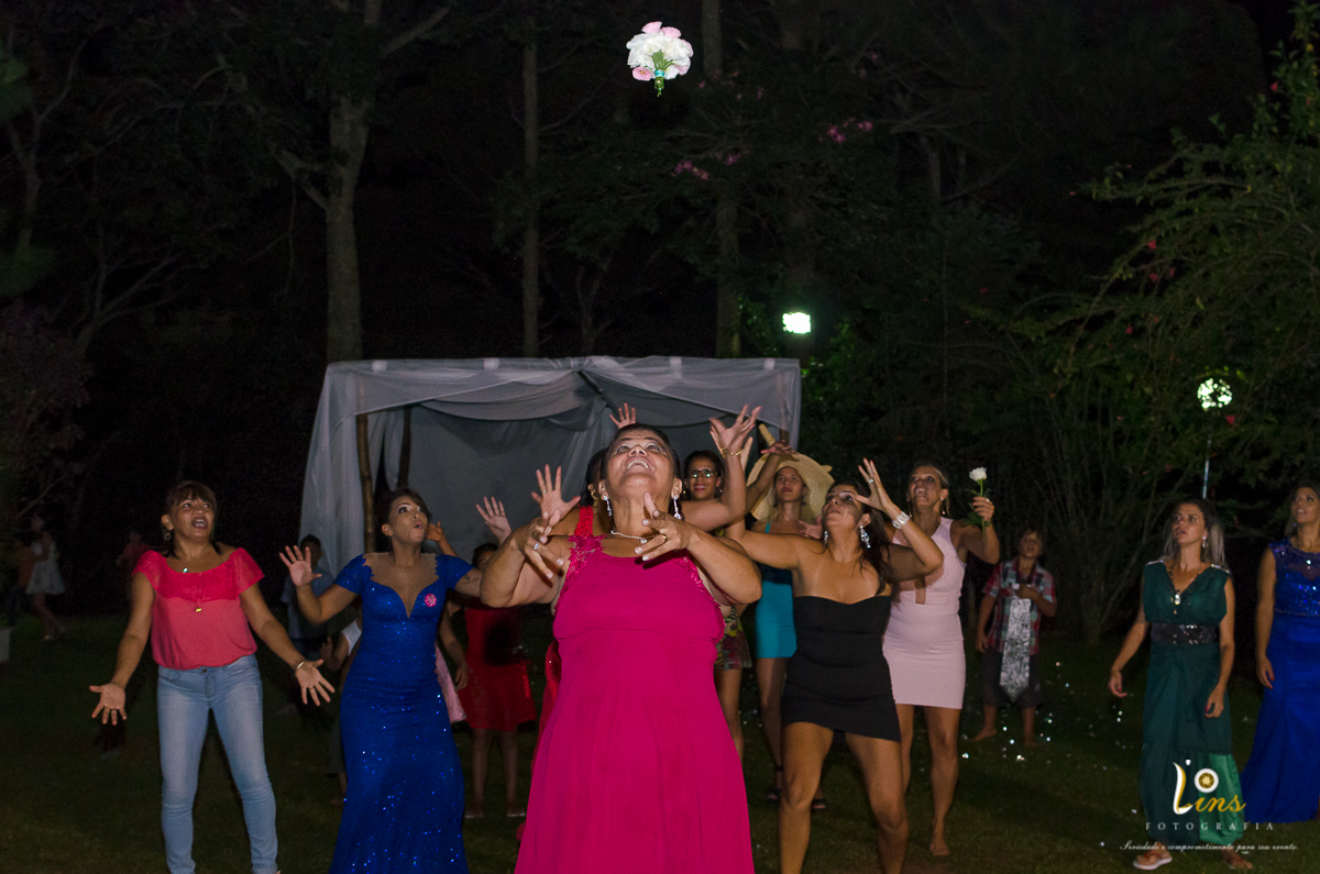 bouquet no alto e convidadas querendo pegar