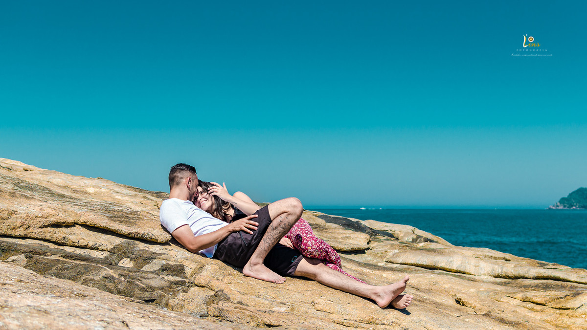 casal deitado nas pedras conversando litoral norte