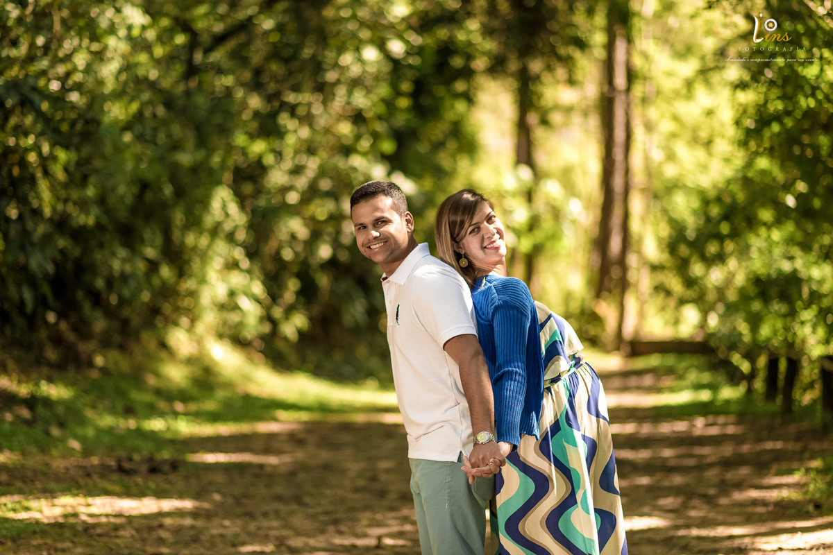casal de costa um para outro e gestante sorrindo