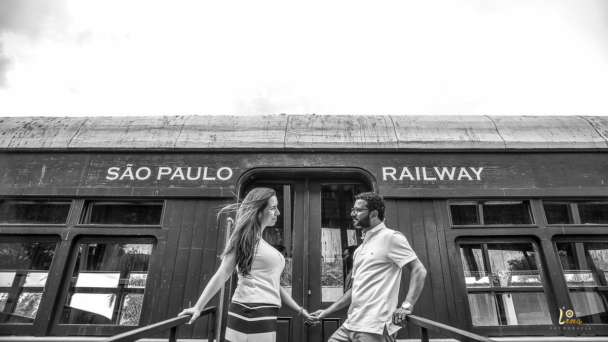 casal de mãos dadas aguardando o trem