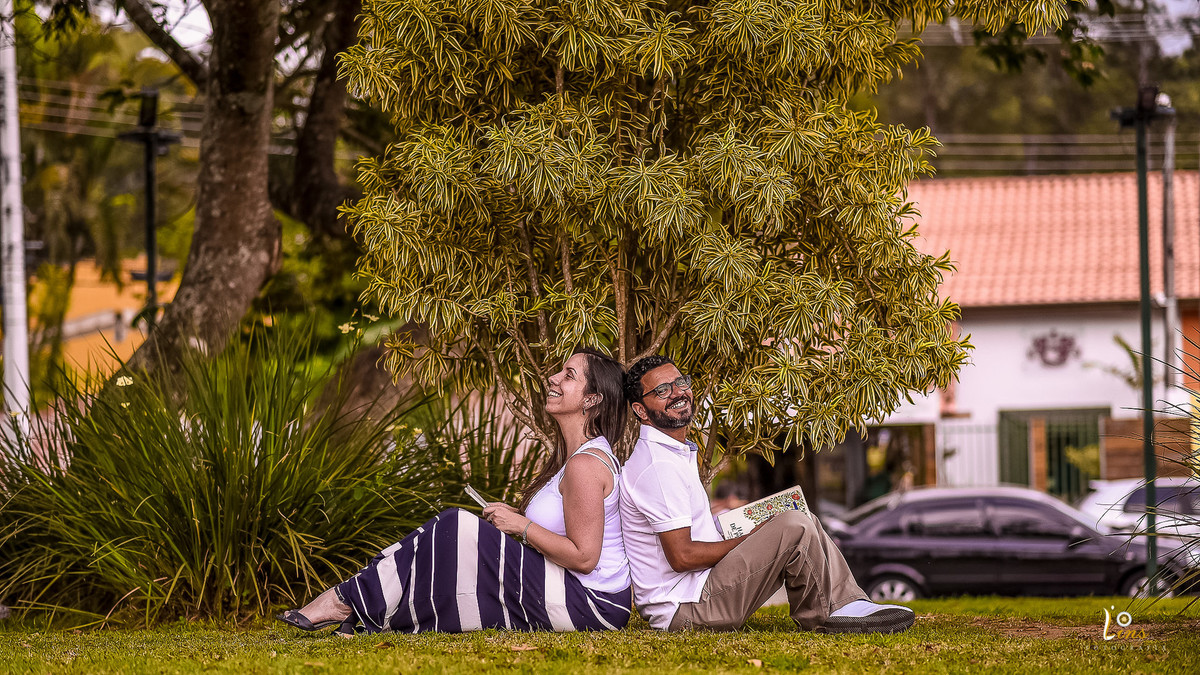 casal lendo e sorrindo na praça