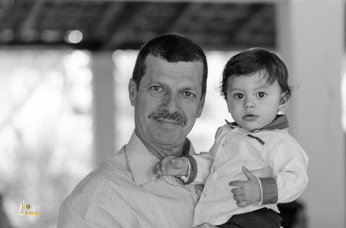 garoto no colo do pai olhando para foto