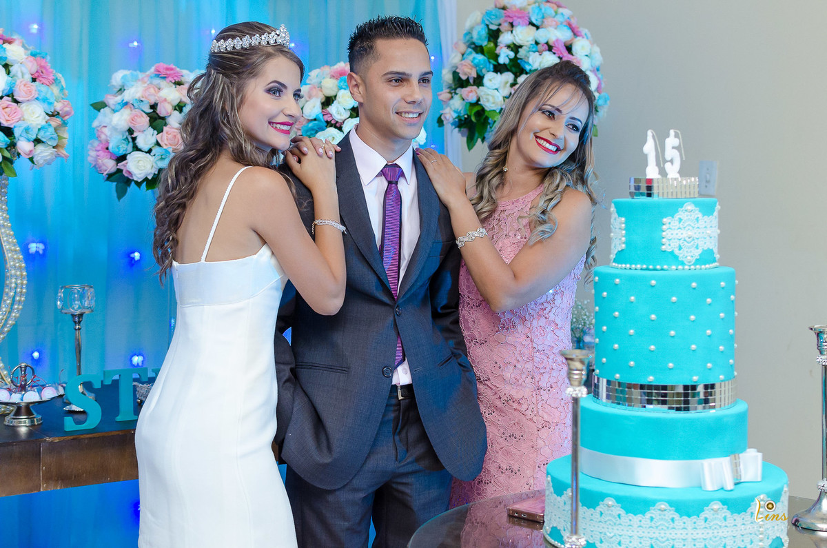 padrasto mãe e filha posando na mesa do bolo