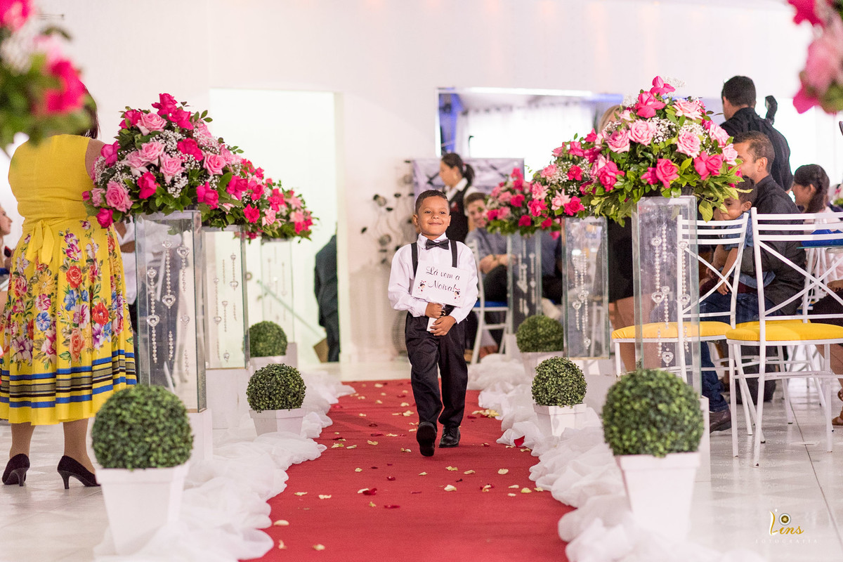 garoto sorrindo com a plaquinha de la vem a noiva, casamento em guarulhos