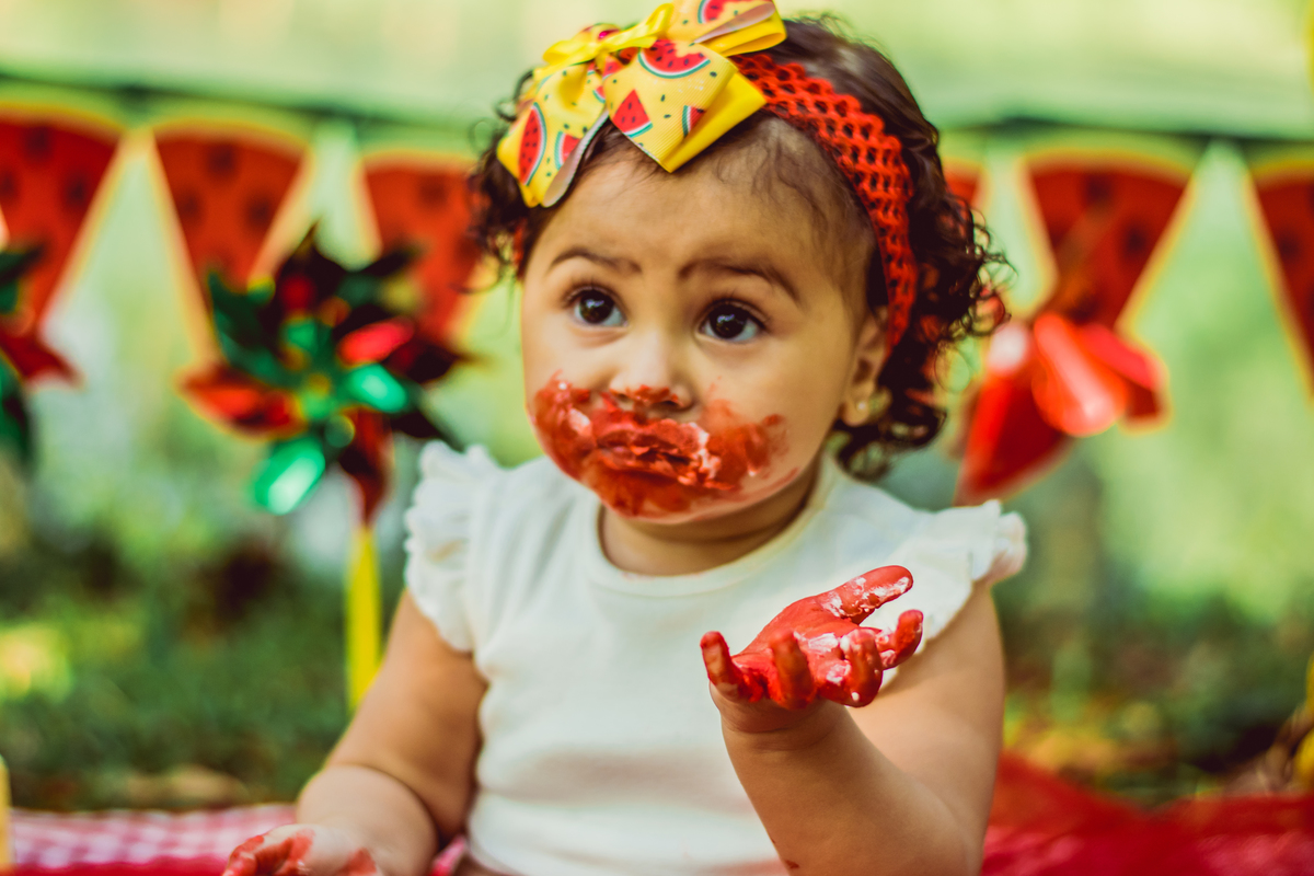 criança com bolo no rosto 