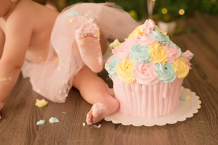 fotografia infantil em caxias do sul 
 menina passando o pé no bolo smash the cake colorido  em Caxias do Sul