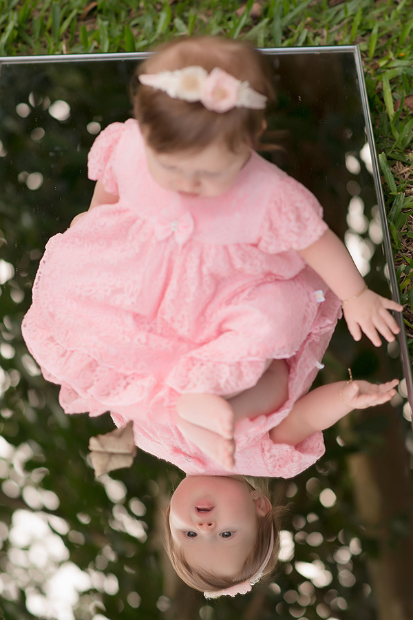 criança de vestido rosa se olhando no espero  em Caxias do Sul
