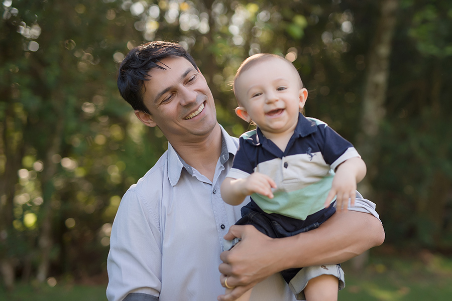 criança sorridente no colo do pai  em Caxias do Sul
