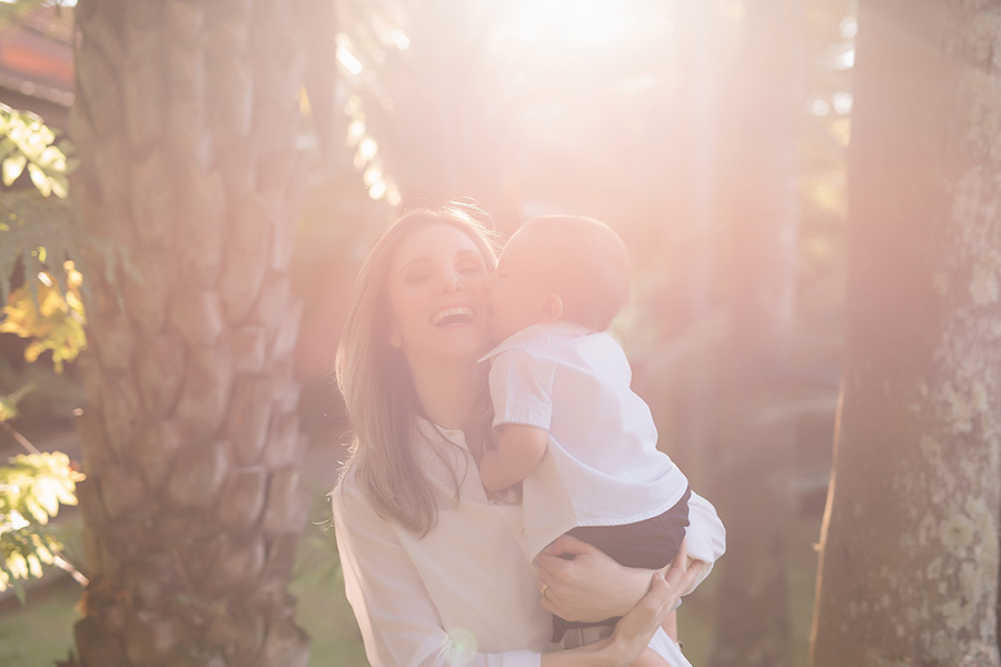 bebe beijando a mãe com o sol aparecendo atrás  em Caxias do Sul