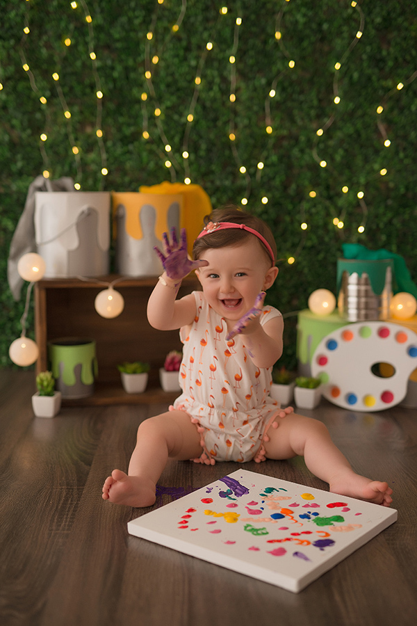 menina usando roupa laranja suja de tinta