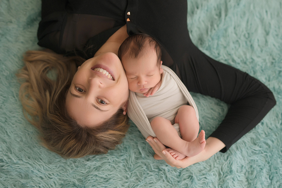 mamãe e bebe na sessão de fotos newborn com fundo azul