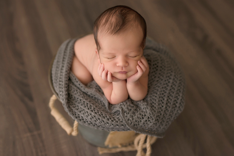 fotógrafa de newborn em caxias do sul bebe no prop cinza pose do sapinho