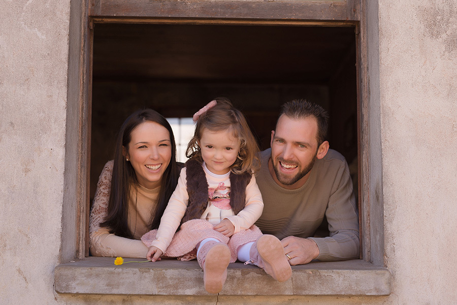 fotografia infantil em caxias do sul; fotografia de família em caxias do sul, menina sentada na janela com os pais