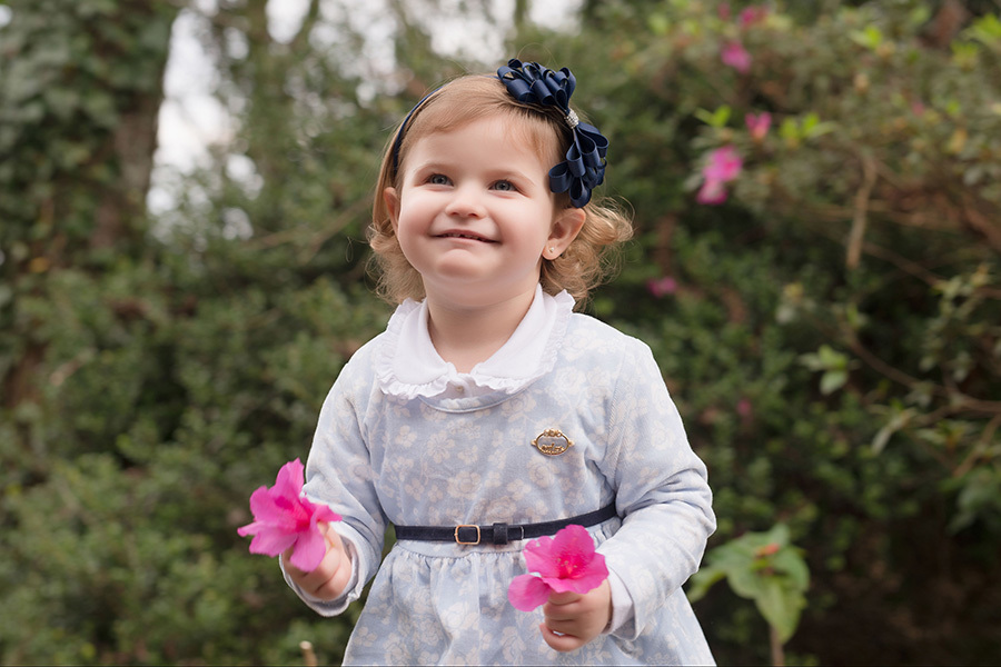 fotografia infantil em caxias do sul; fotografia de família em caxias do sul, menina de azul segurando flores