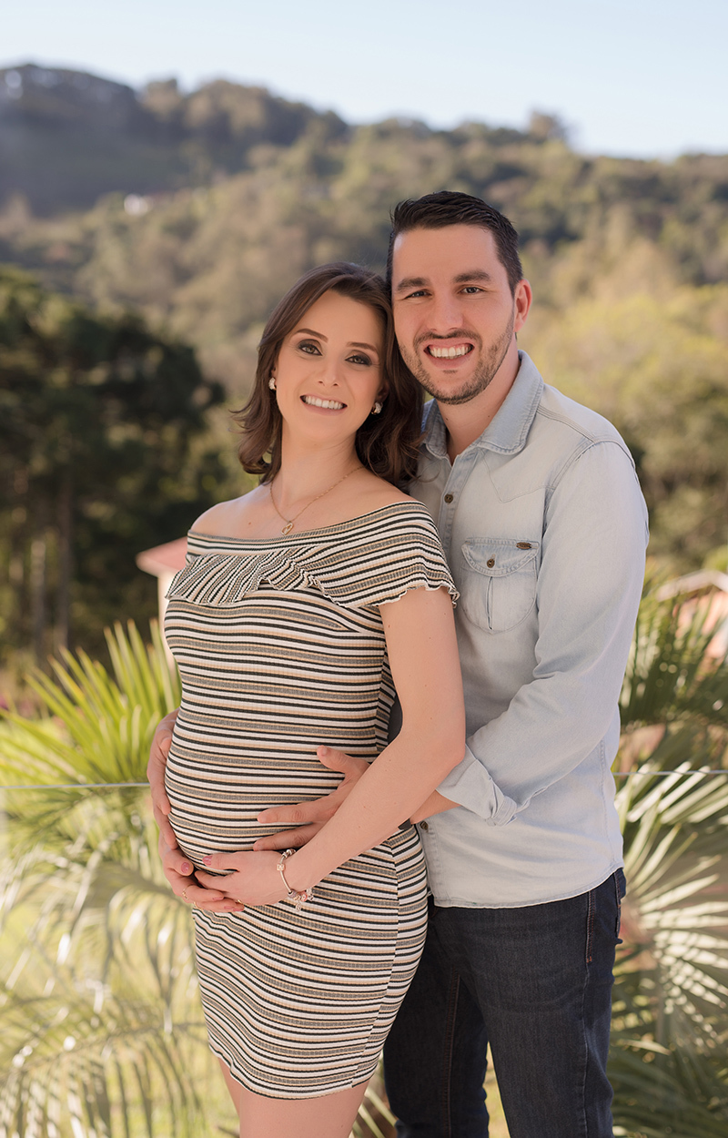 fotografia de gestante caxias do sul Morgana Perini; gestante com vestido listrado e o marido abraçando