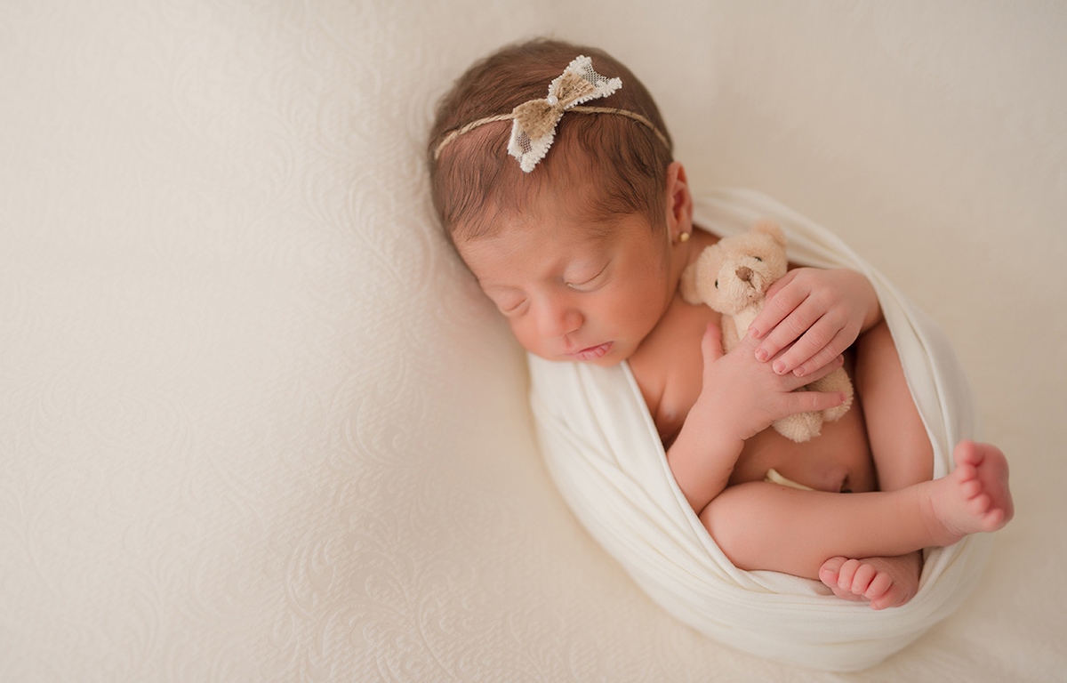 foto de newborn em caxias do sul fotografa morgana perini bebe com headband e ursinho enrolada em tecido