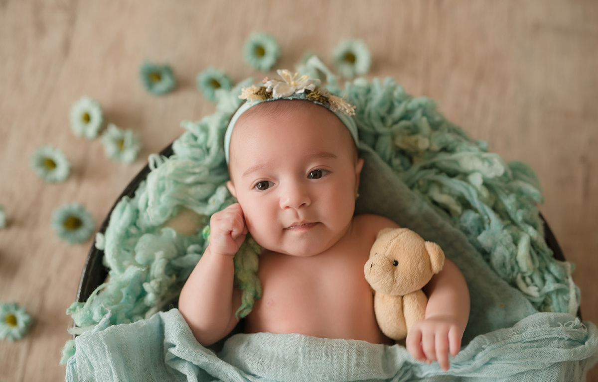 foto de bebe em caxias do sul fotografa morgana perini bebe com deitada sobre tecido verde e ursinho