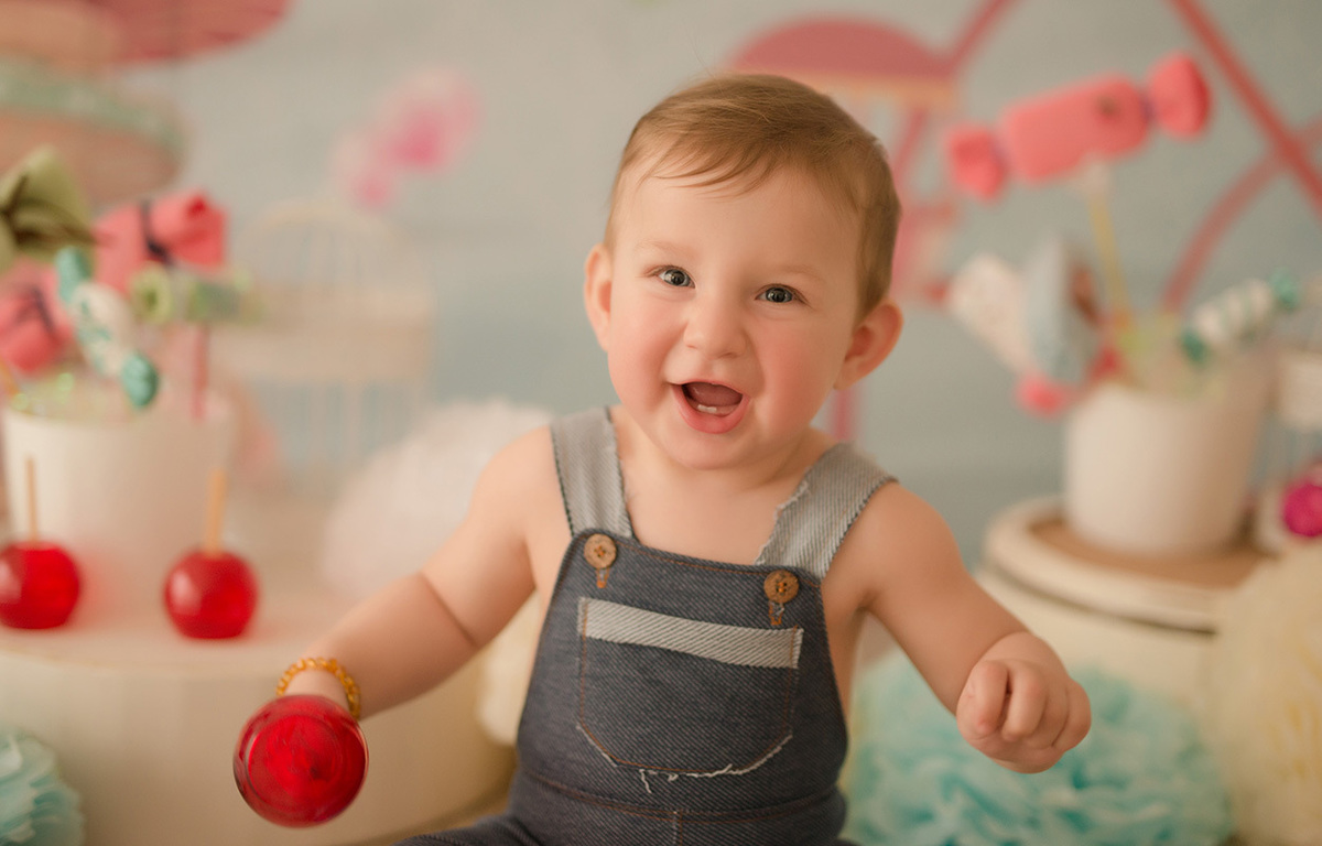 foto de bebe em caxias do sul fotografa morgana perini bebe rindo com bolinha vermelha na mão