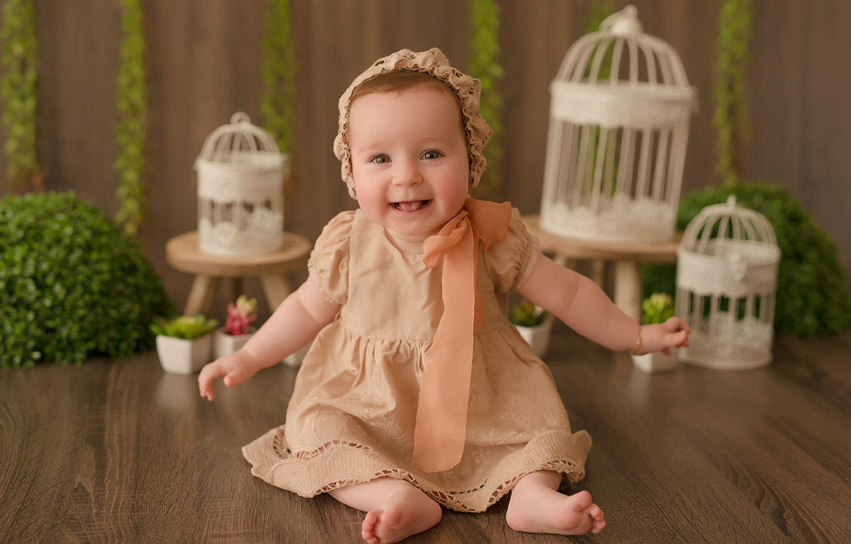 foto de bebe em caxias do sul fotografa morgana perini menina de vestido bege em cenario de gaiolas brancas