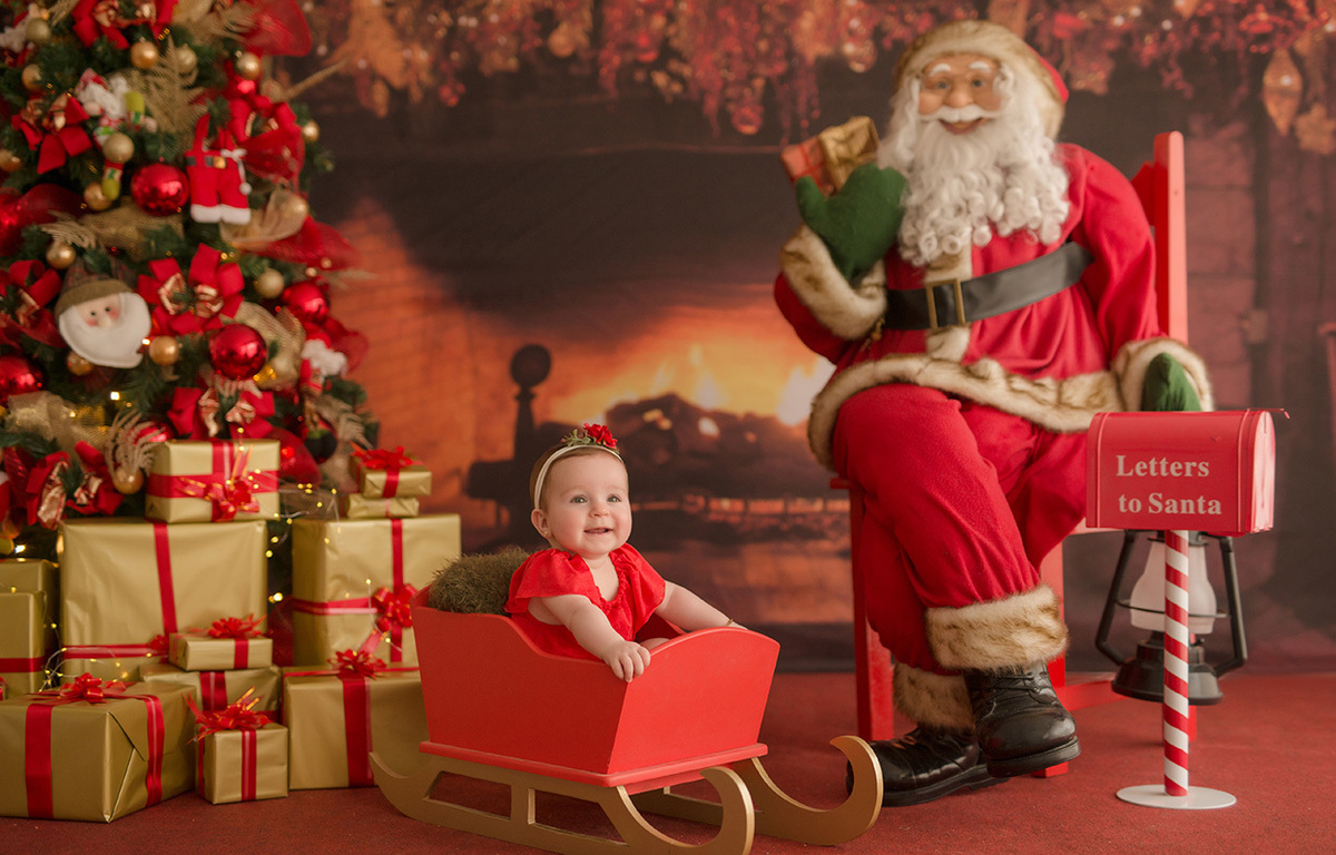 foto de bebe em caxias do sul fotografa morgana perini menina de vestido vermelho dentro do trenó