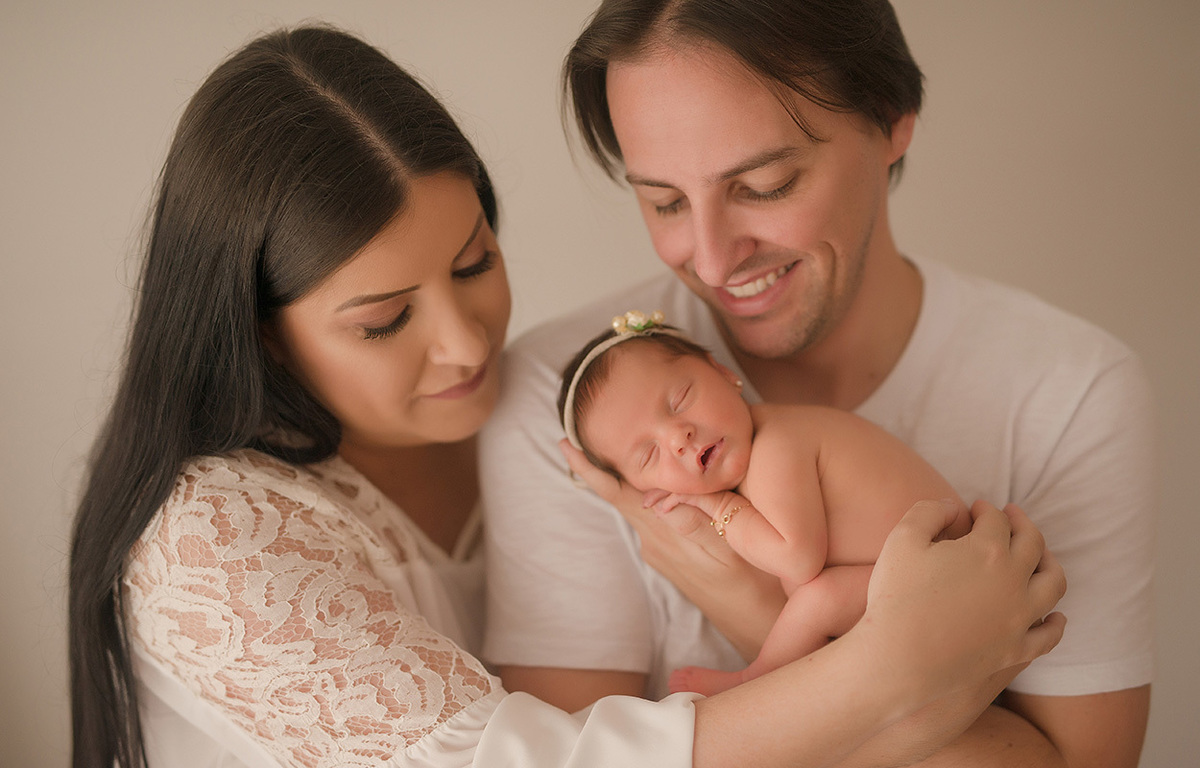 foto newborn em caxias do sul fotografa morgana perini mãe com blusa de renda e pai com bebe nos braços