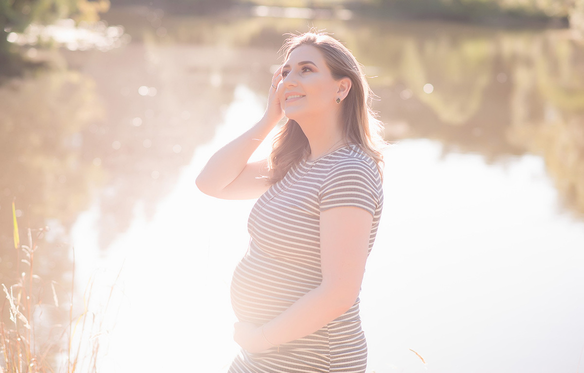 foto de gestante em caxias do sul fotografa Morgana Perini gestante de lado na frente de uma lago