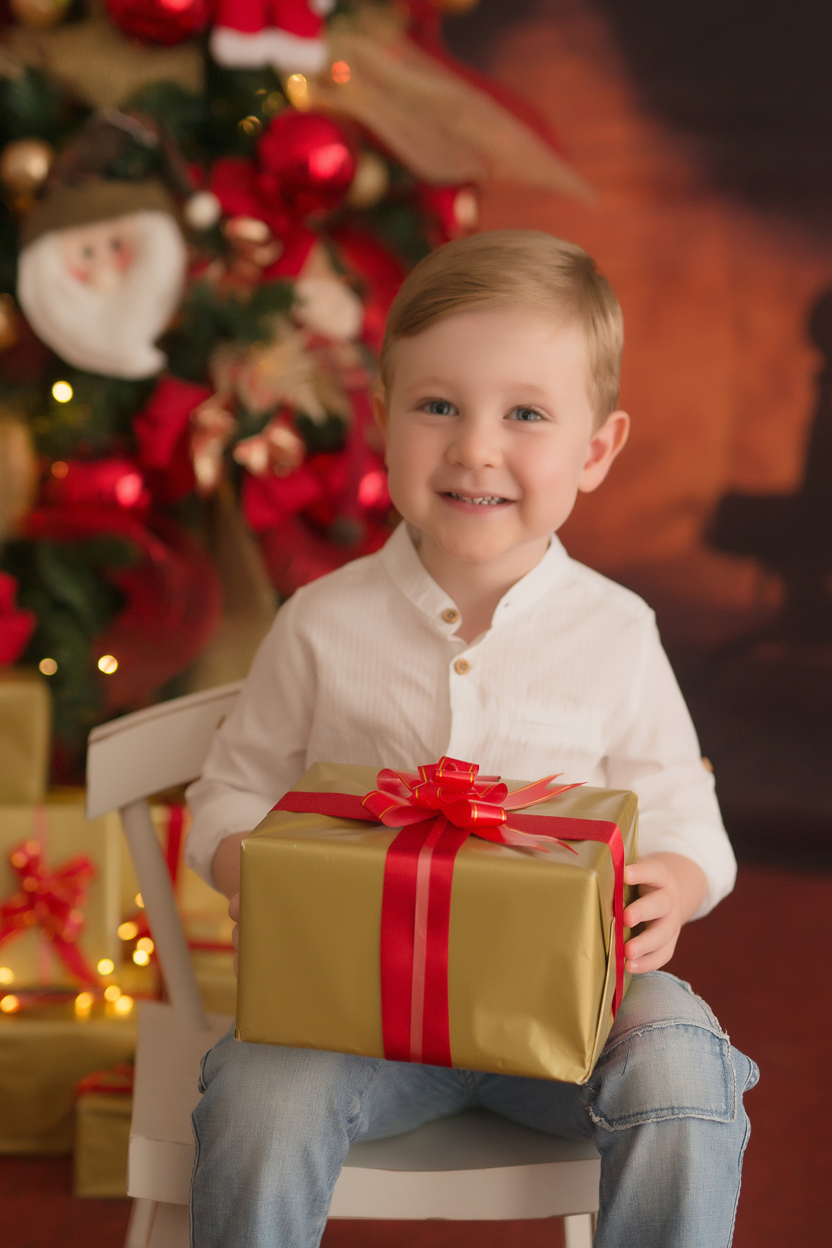 foto de criança em caxias do sul fotografa morgana perini menino com presente nas mãos