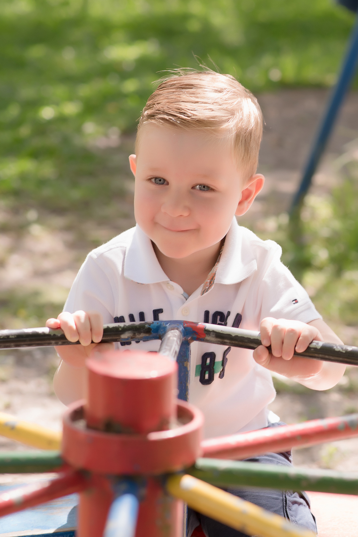 foto de criança em caxias do sul fotografa morgana perini menino com camisa branca em parquinho