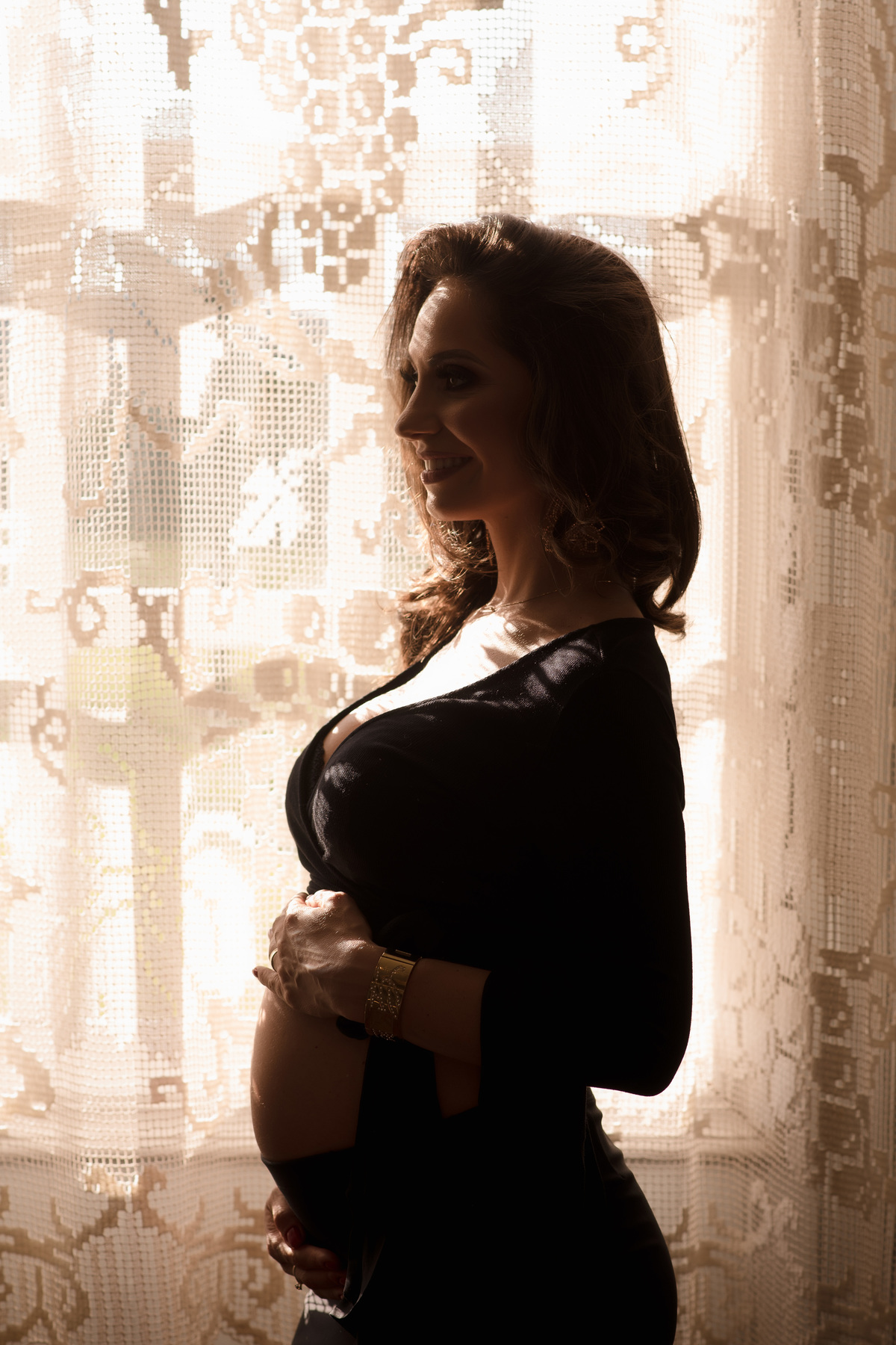 foto gestante em caxias do sul fotografa morgana perini mulher gestante de roupa preta em frente a uma janela