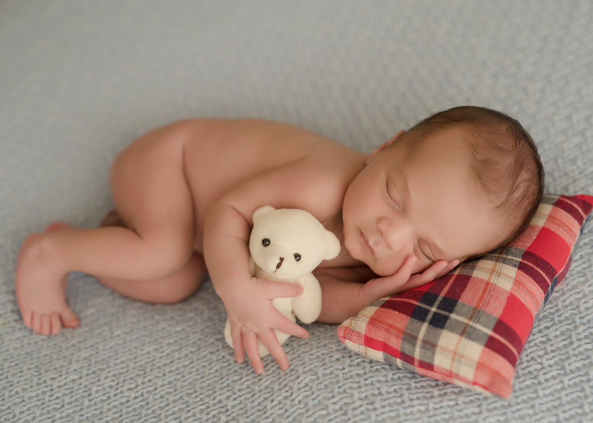 foto de bebe em caxias do sul fotografa morgana perini bebe deitado em almofada xadrez vermelha