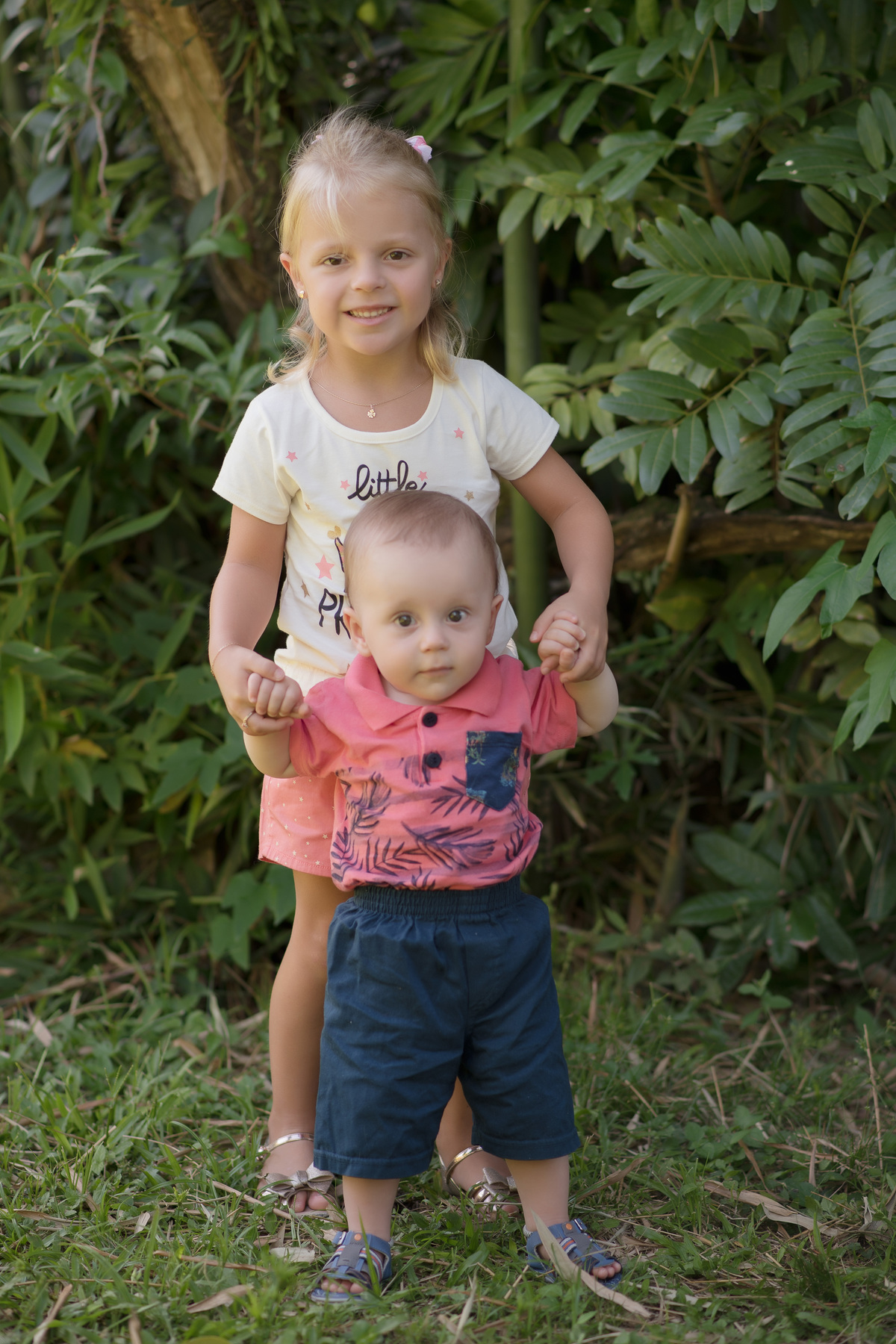 foto de bebe em caxias do sul fotografa morgana perini irmã segurando irmãozinho pelas mãos