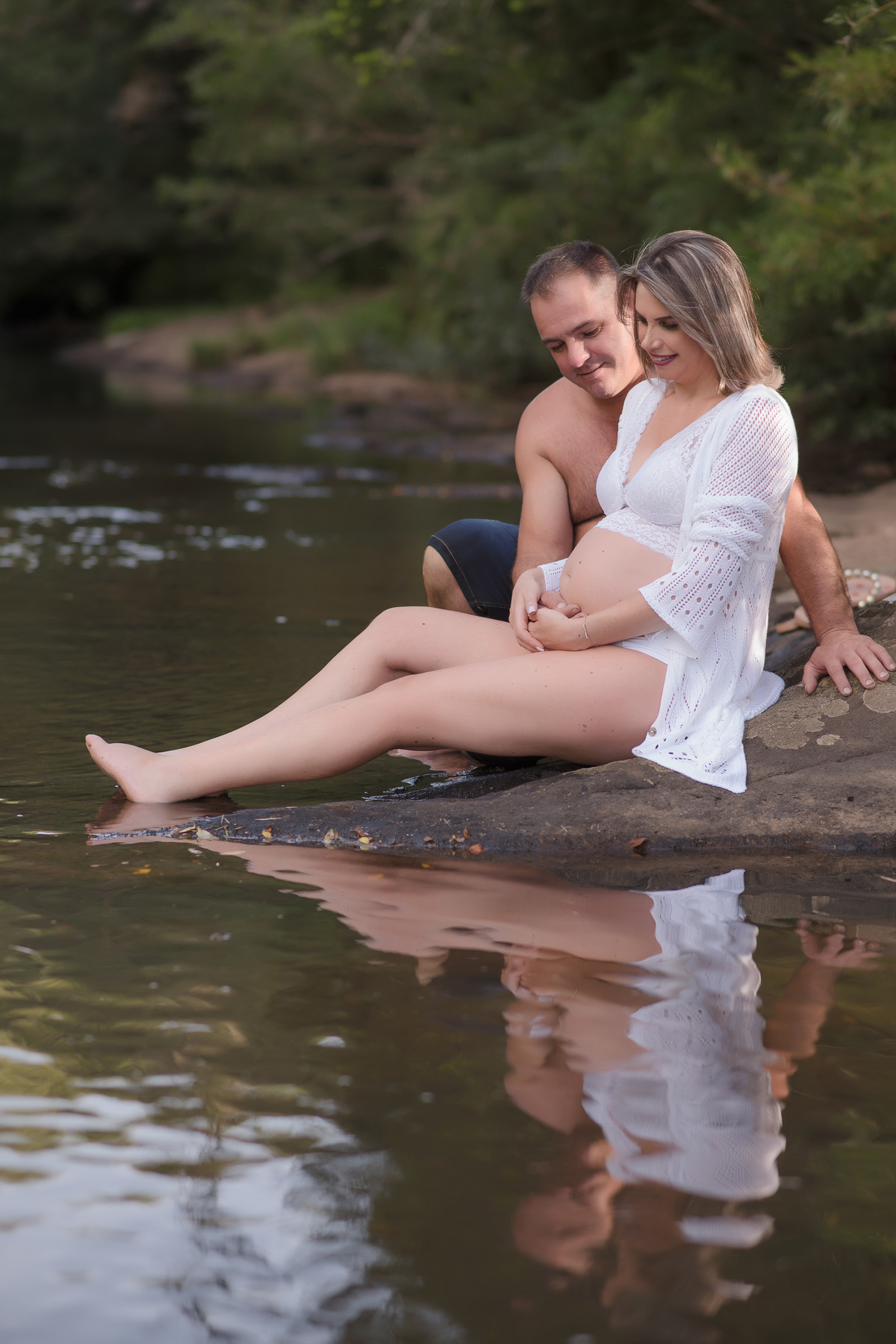 foto de familia em caxias do sul fotografa morgana perini casal sentado na beira de um rio