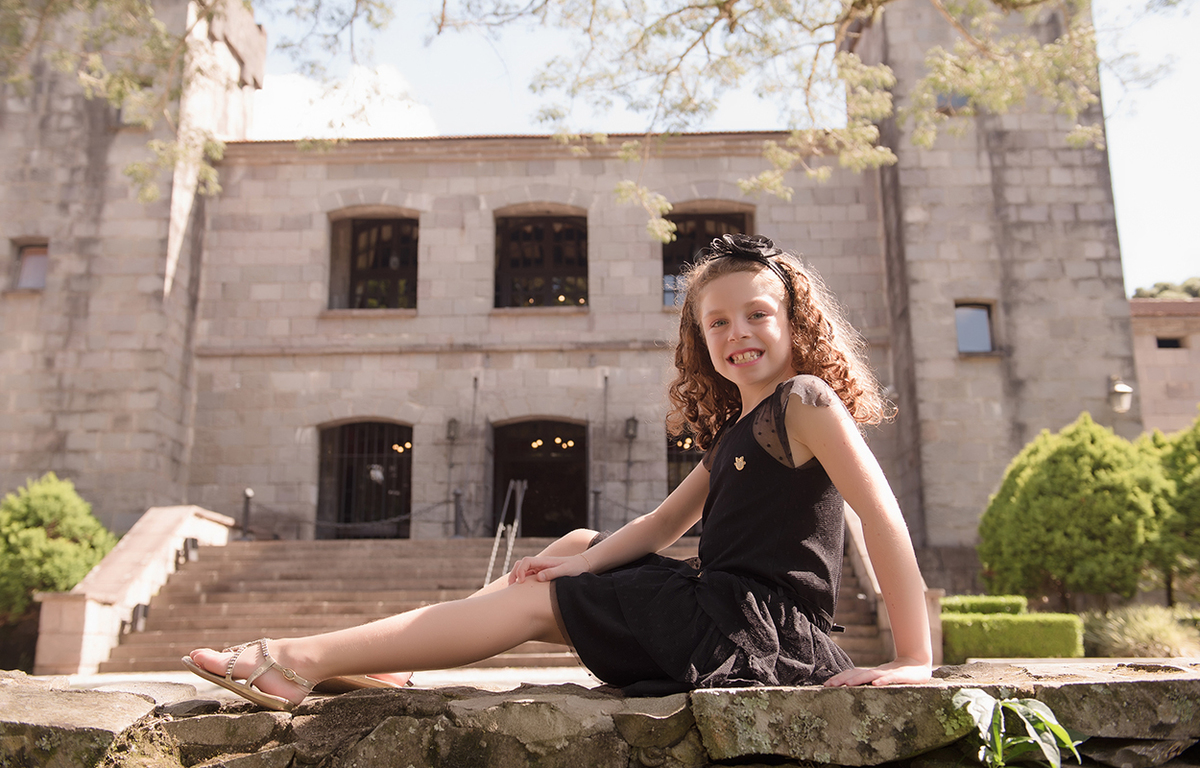 foto de menina em caxias do sul fotografa morgana perini menina de vestido preto em frente a castelo
