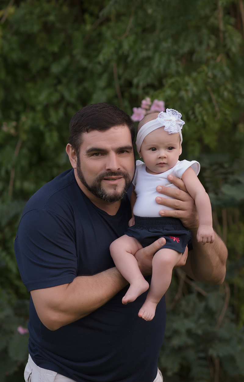 foto de bebe em caxias do sul fotografa morgana perini bebe nos braços do pai com laço no cabelo