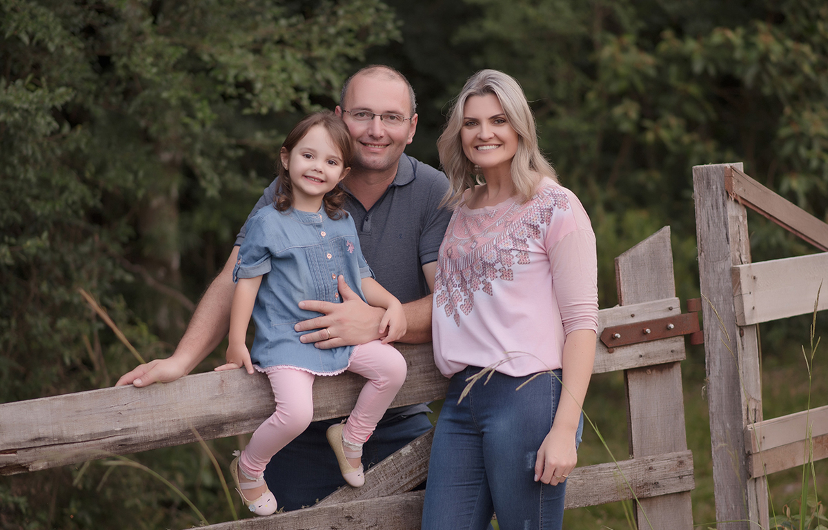 foto de menina em caxias do sul fotografa morgana perini menina sentada na porteira com os pais