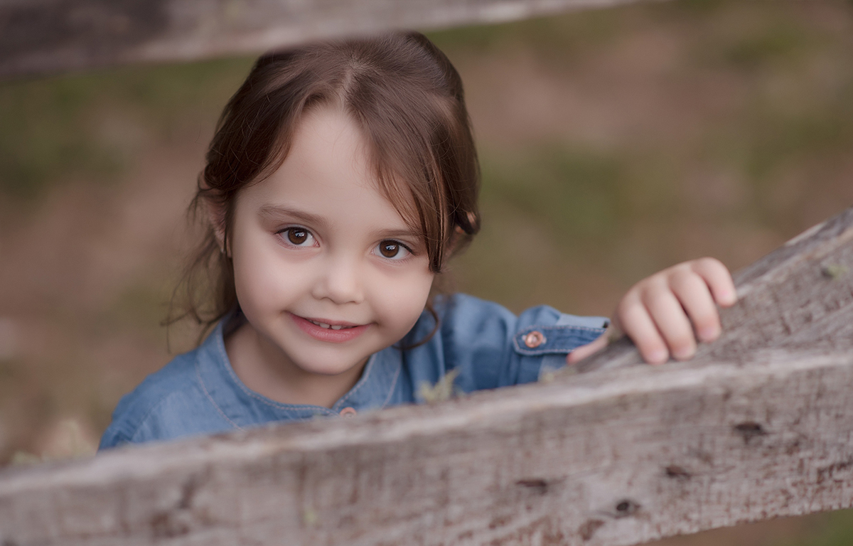 foto de menina em caxias do sul fotografa morgana perini menina atras de portão de madeira