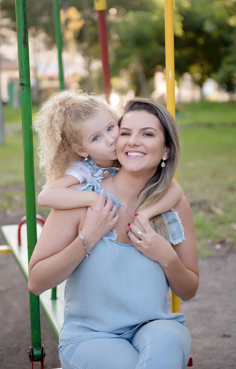 Foto de criança em caxias do sul fotografa morgana perini filha beijando a mae em parquinho
