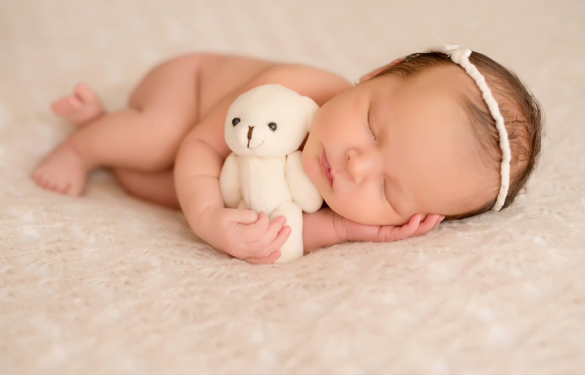 Foto de recém nascido em caxias do sul fotografa morgana perini bebe abraçada em ursinho