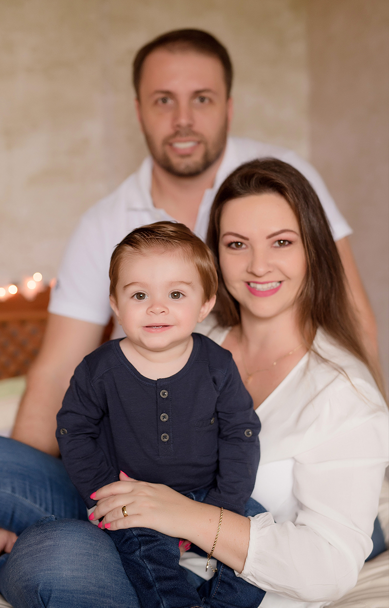 Foto de recém nascido em caxias do sul fotografa morgana perini pais com filho sentados na cama