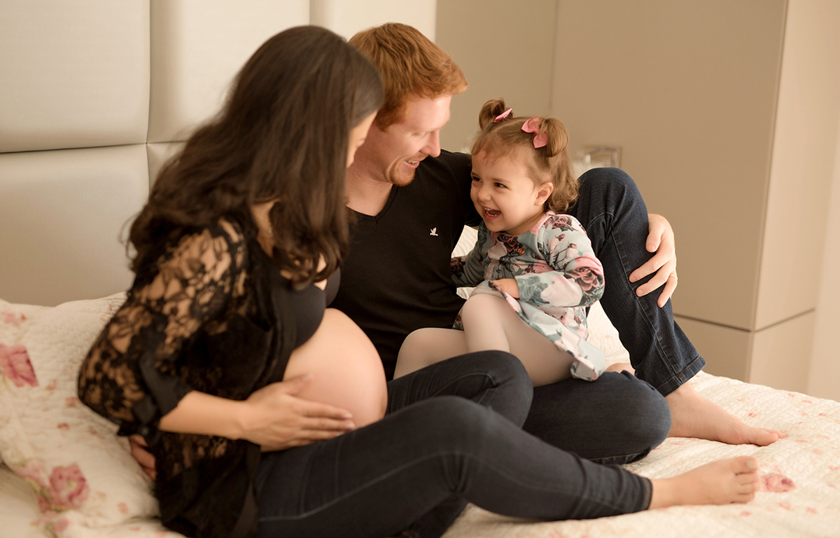 foto de bebe em caxias do sul fotografa morgana perini pais sentados na cama com a filha