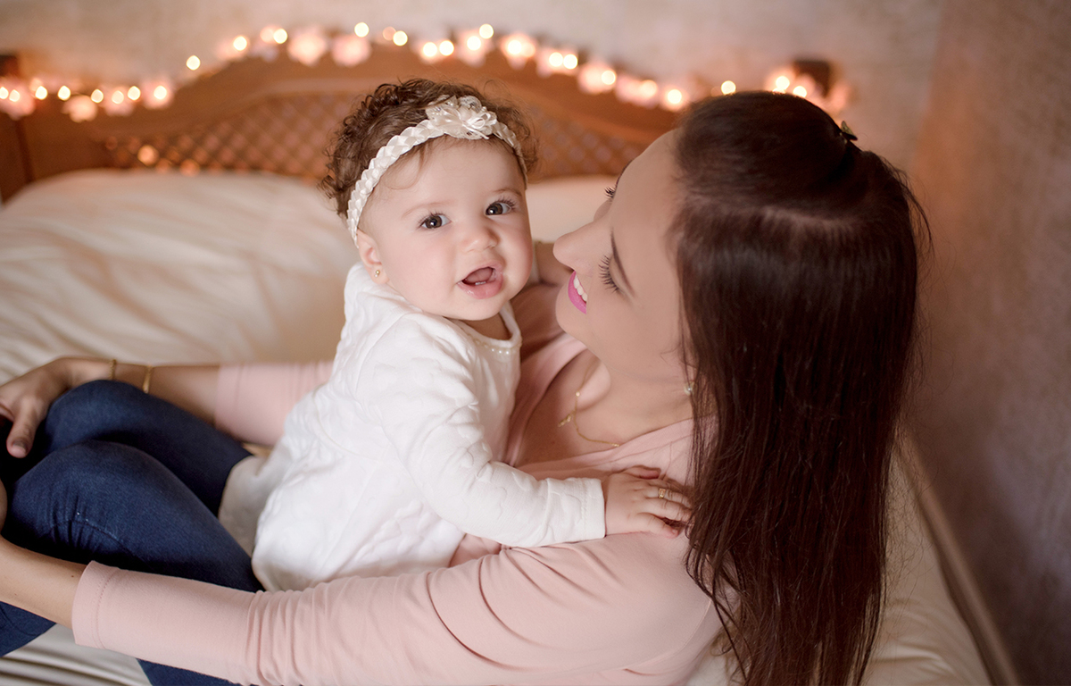 foto de bebe em caxias do sul fotografa morgana perini mae sentada na cama com bebe