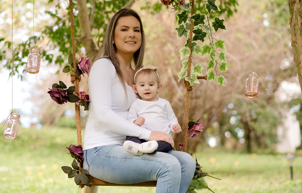 foto de familia em caxias do sul fotografa morgana perini filha no colo da mae em balanço em meio a arvores