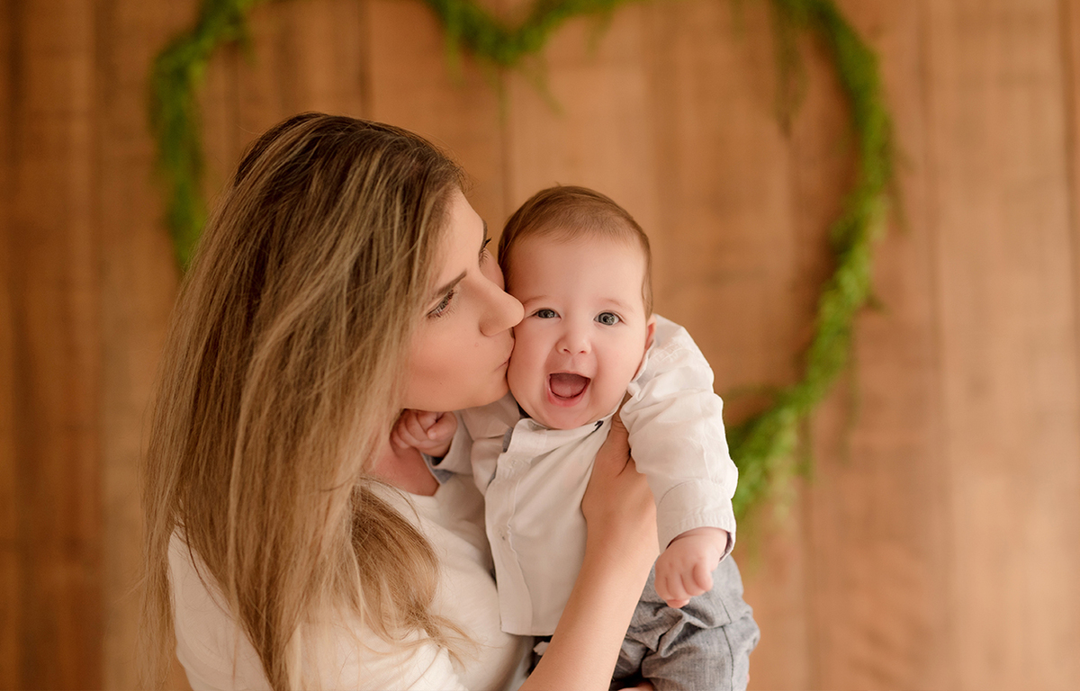 foto de bebe em caxias do sul fotografa morgana perini bebe sorrindo com beijo da mae