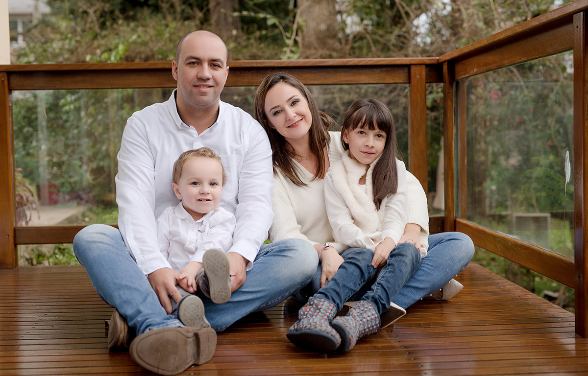 foto de familia em caxias do sul fotografa morgana perini famila sentada na varanda sorrindo