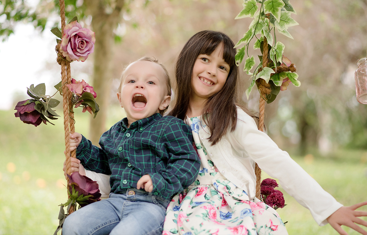 foto de familia em caxias do sul fotografa morgana perini irmãos sentados no balanço brincando